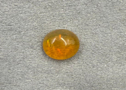 Round amber gemstone on a gray textured background
