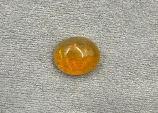 Round amber gemstone on a gray textured background