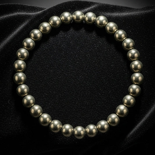 Natural 8mm raw Pyrite gemstone bracelet with metallic gold luster on a velvet surface