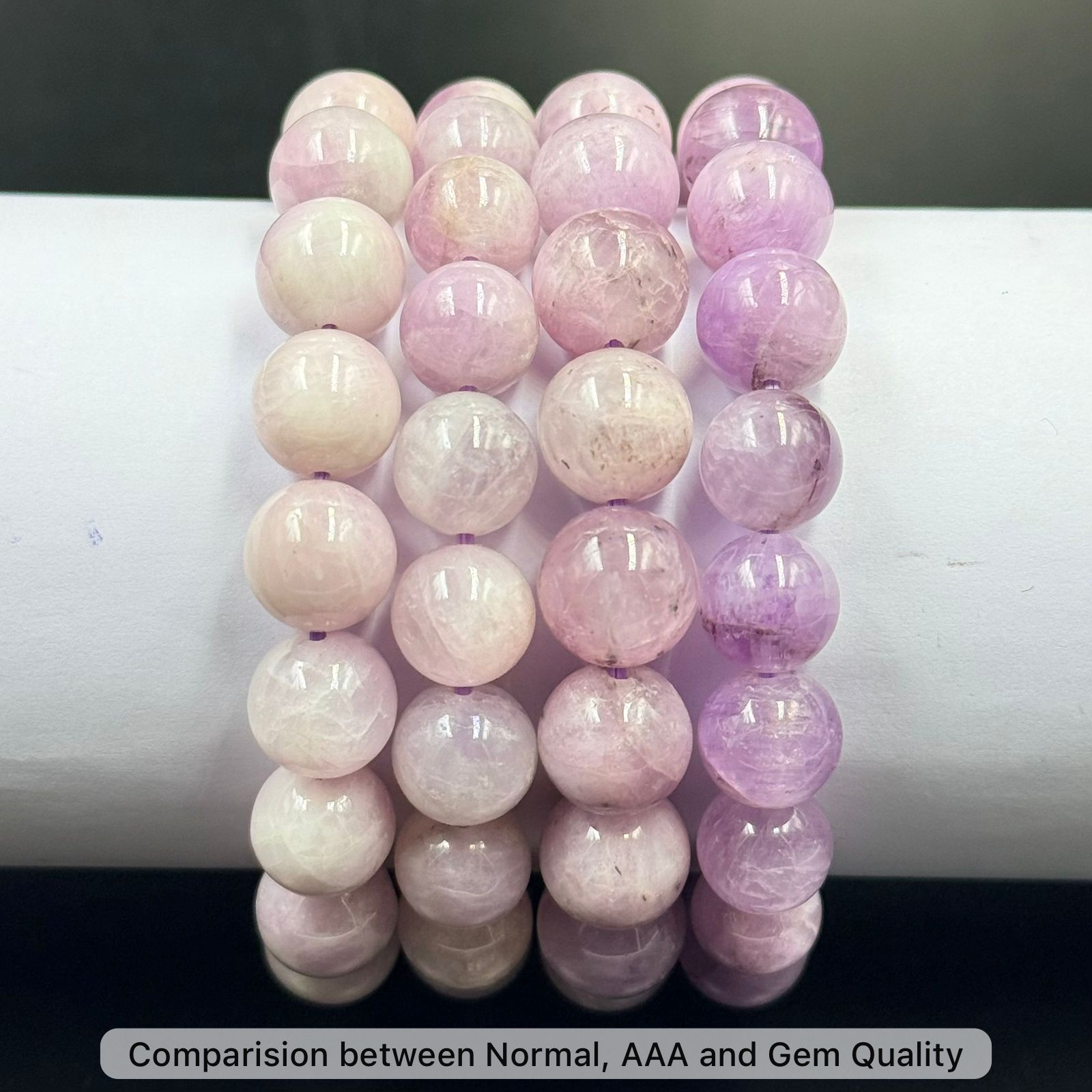 Four strands of Pink Kunzite Bracelet beads in varying shades of light pink and purple, arranged side by side on a white c...