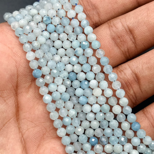 Close-up of aquamarine 4mm faceted mala beads in hand