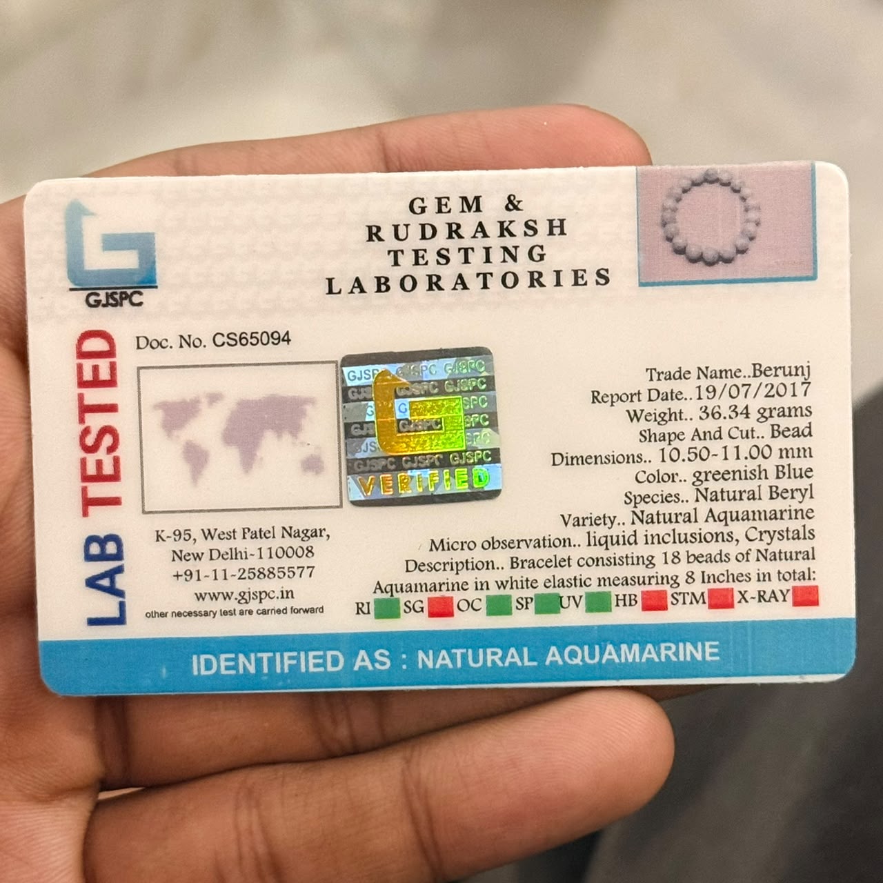 Certification card for Aquamarine Bracelet from Gem & Rudraksh Testing Laboratories held in hand