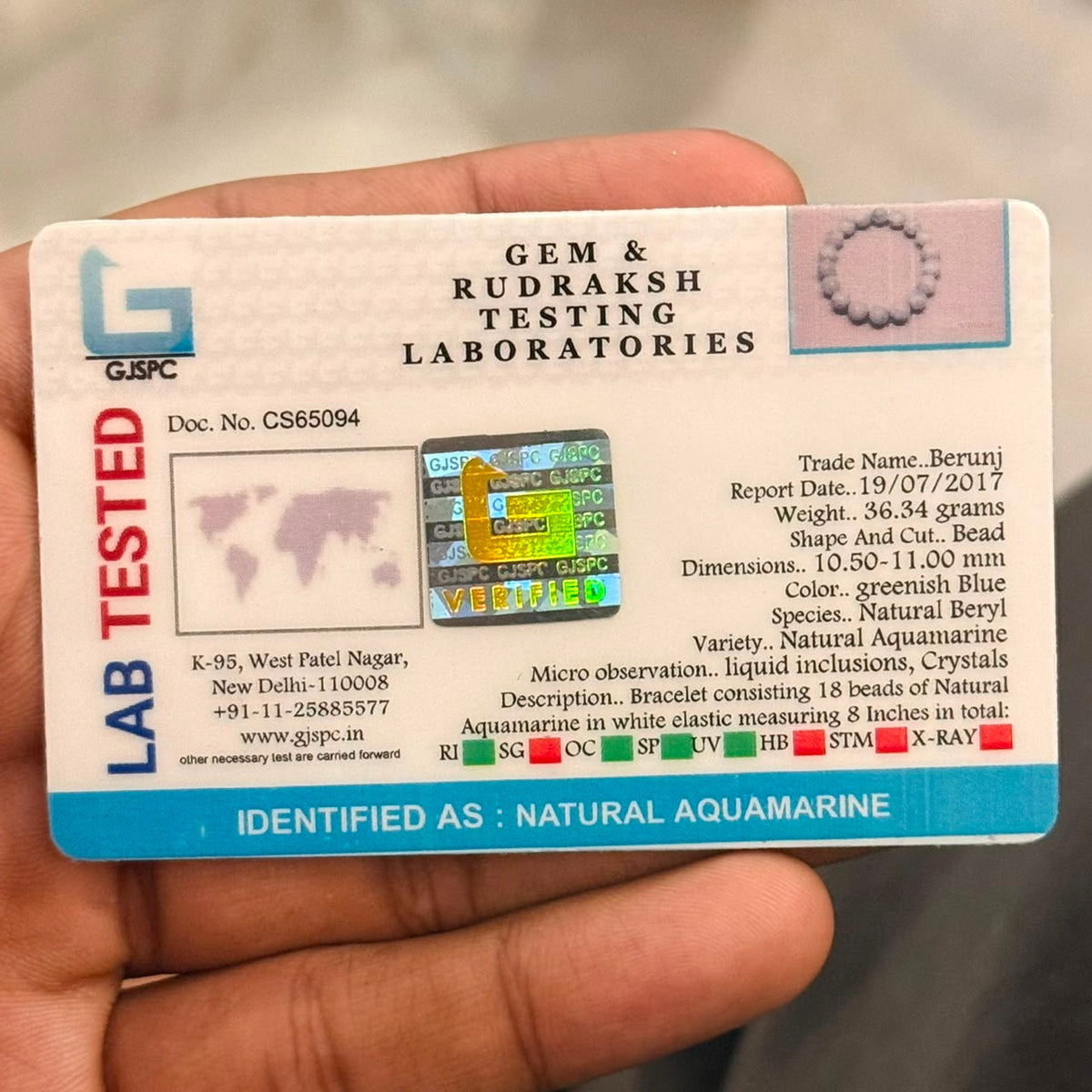 Certification card for Aquamarine Bracelet from Gem & Rudraksh Testing Laboratories held in hand