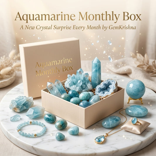 Aquamarine Monthly Box with blue crystal stones, bracelet, and jewelry on a marble surface
