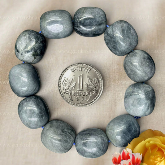 Black cat's eye tumble bracelet with round gray-blue beads arranged around a one rupee coin
