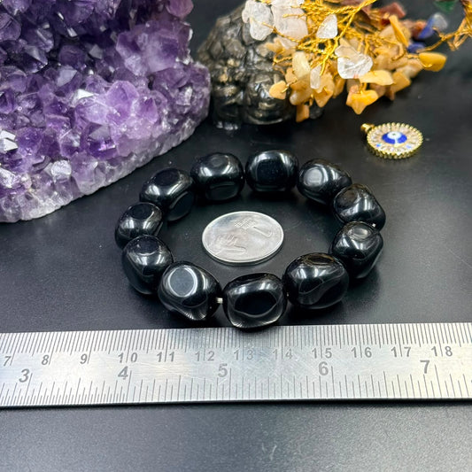 Black onyx tumble bracelet with beads laid out and ruler for size on tabletop