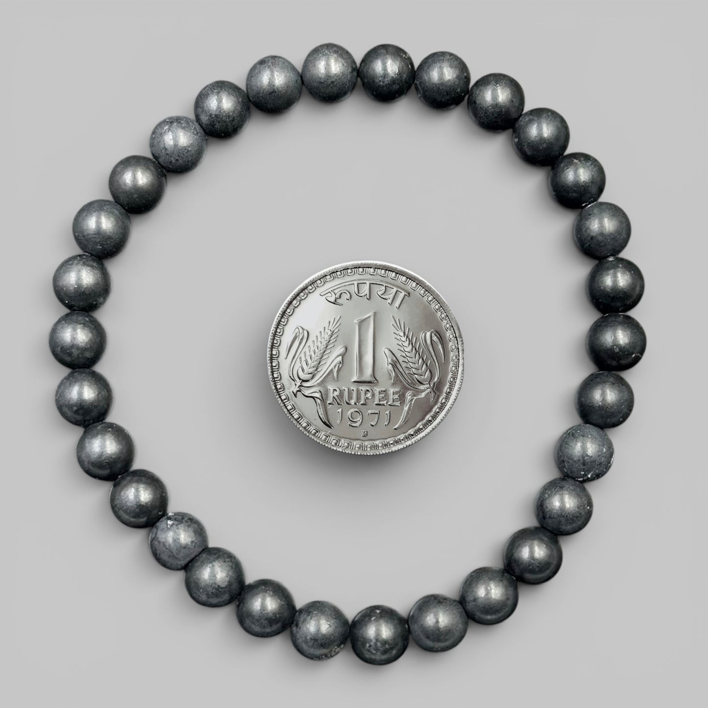 Black shungite bead bracelet with metallic dark luster round stones and coin centerpiece