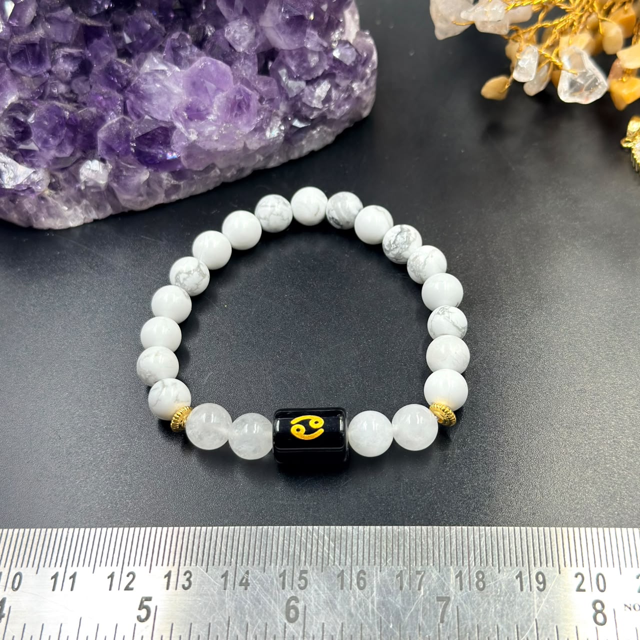 Cancer (Karka) zodiac bracelet on dark surface with howlite beads, gold accents, crab charm
