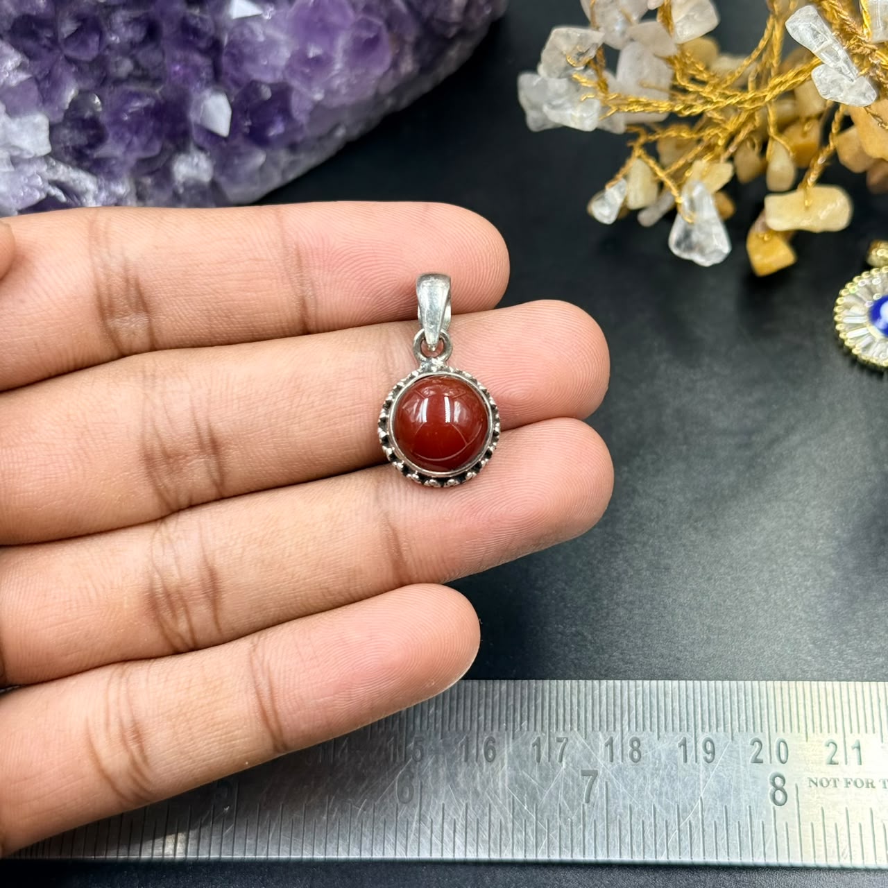 Carnelian 925 silver locket pendant small round red gemstone close-up held over ruler