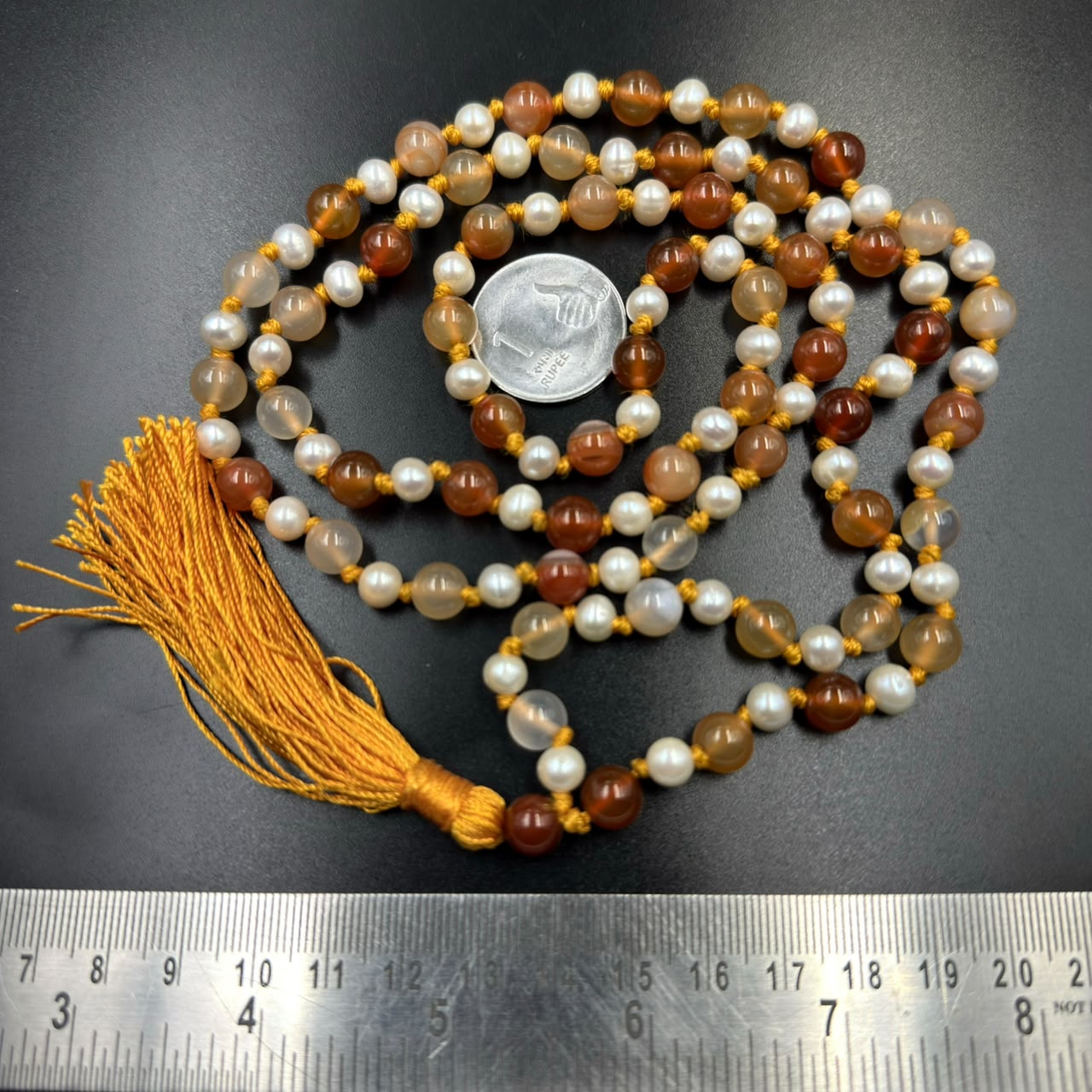 Carnelian 8mm and pearl 6mm Jaap mala beads with tassel and measuring scale background