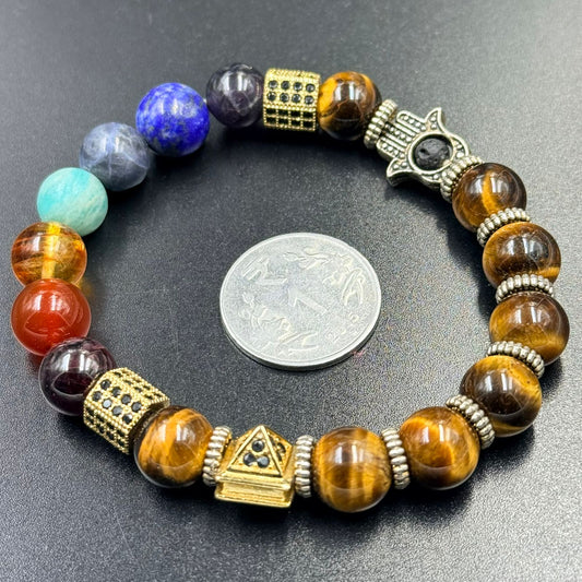 Close-up of chakra fusion bracelet beads with gold-tone charms on dark gray background