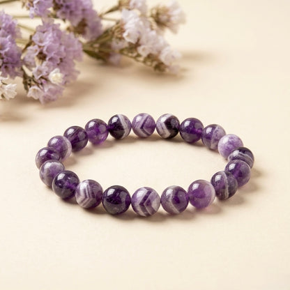 Chevron amethyst bracelet made of round purple beads with light banded chevron patterns