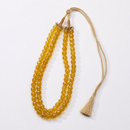 Citrine faceted 2-line mala necklace laid flat with gold cord tassel