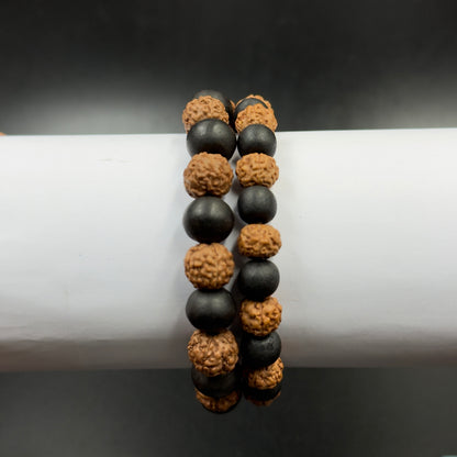 Close-up of a 5 Mukhi rudraksh and karungali bead bracelet showing black beads and tan rudraksh