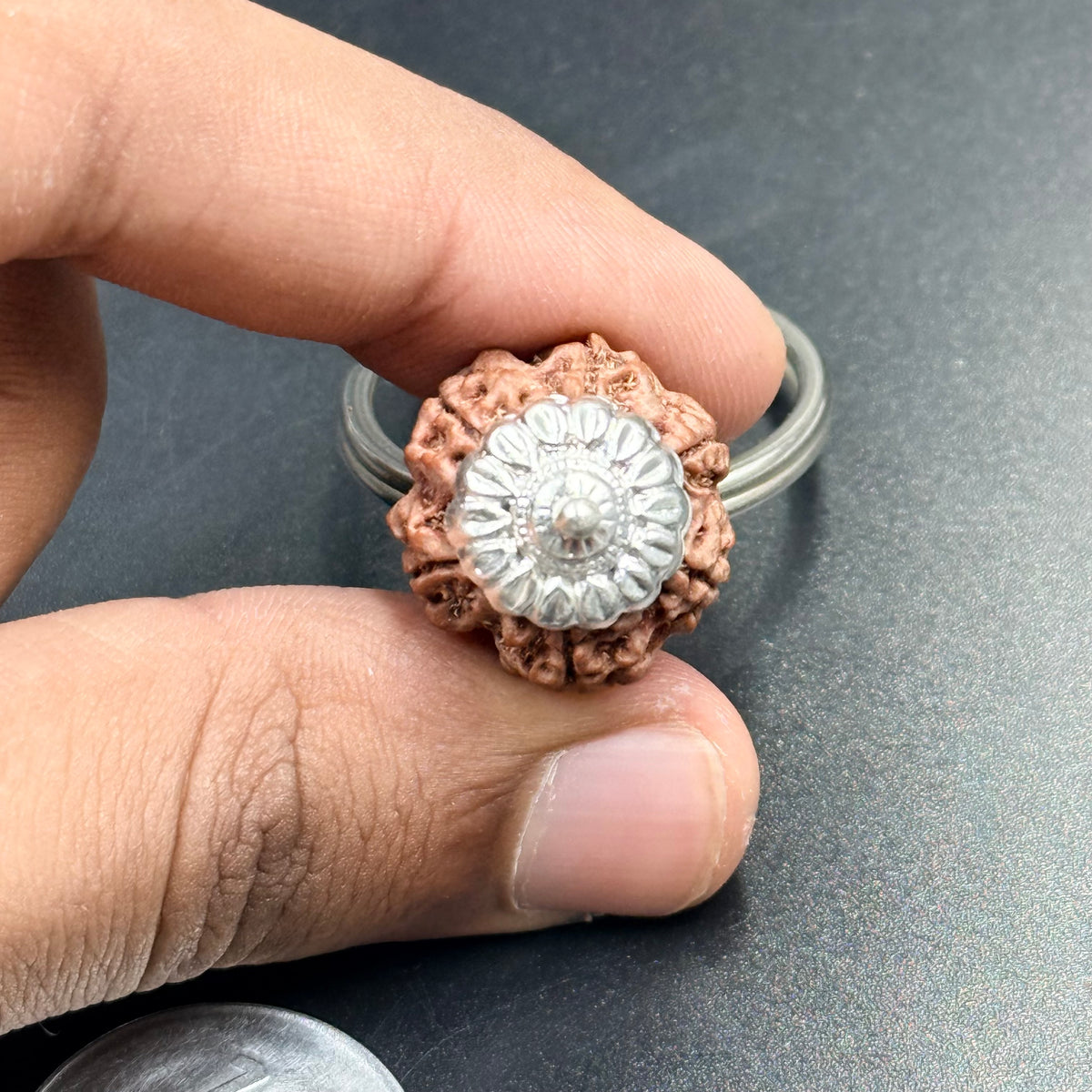 Close-up of rudraksha keychain 4 5 6 mukhi pendant in hand with silver-tone ring