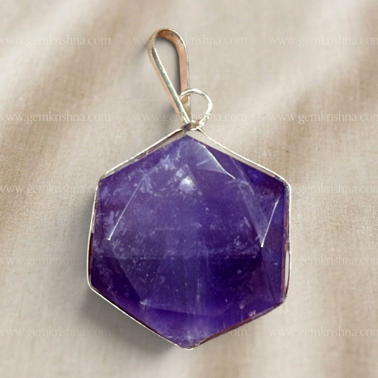 Close-up natural amethyst hexagon locket pendant with gold-tone frame and loop bail