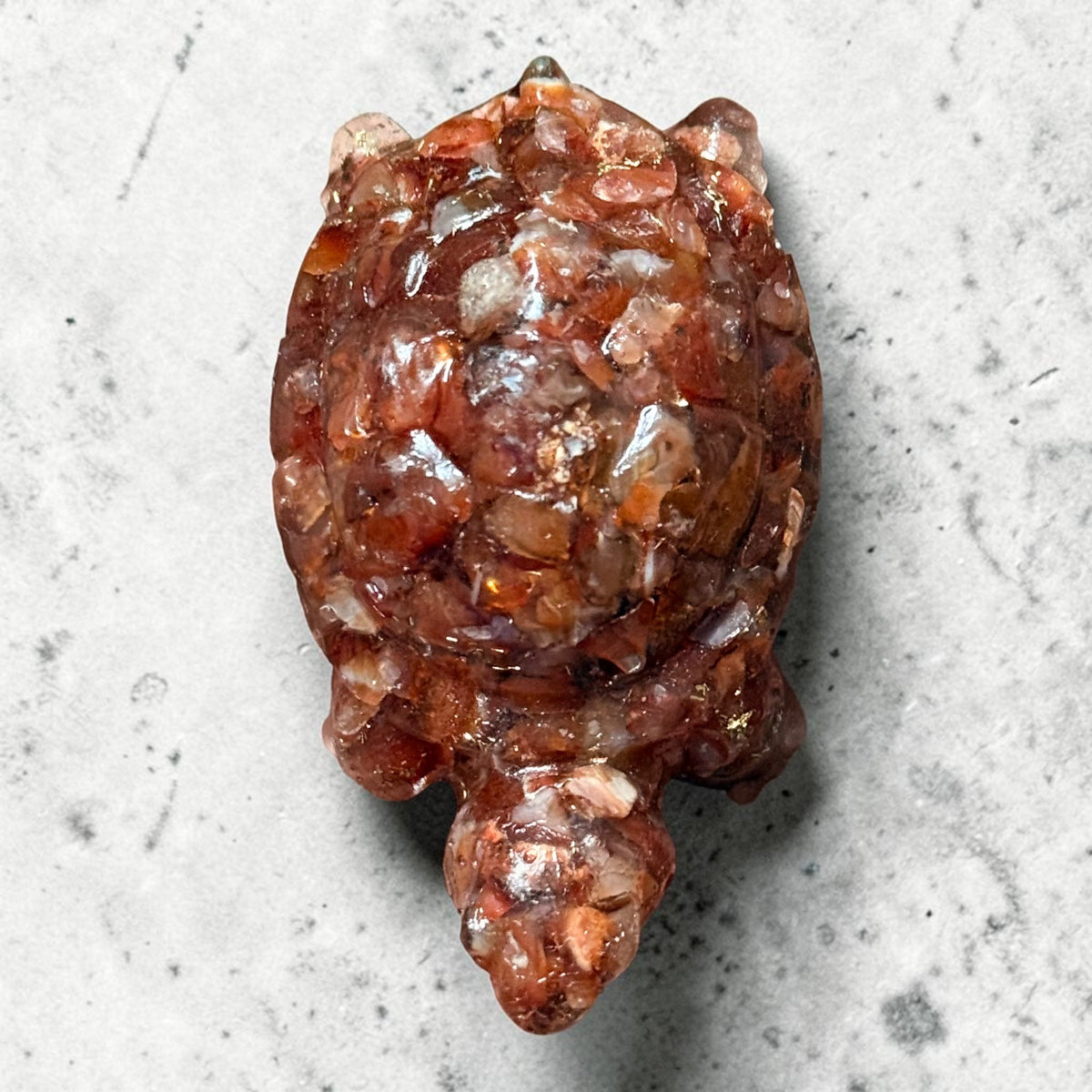 Close-up of natural carved carnelian turtle figurine face and shell texture