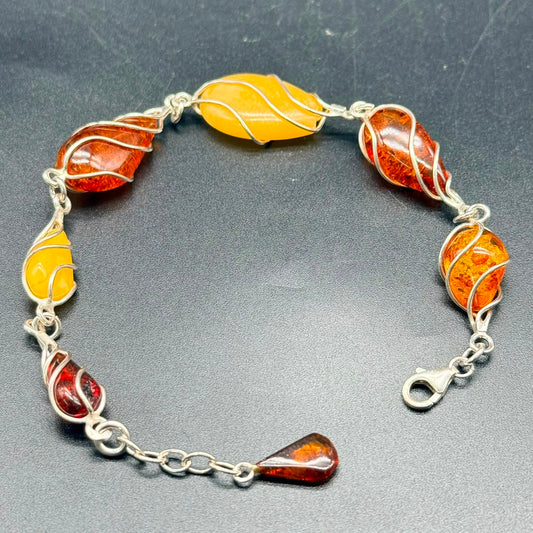 Close-up of 925 sterling silver amber link bracelet with lobster clasp and yellow amber drop