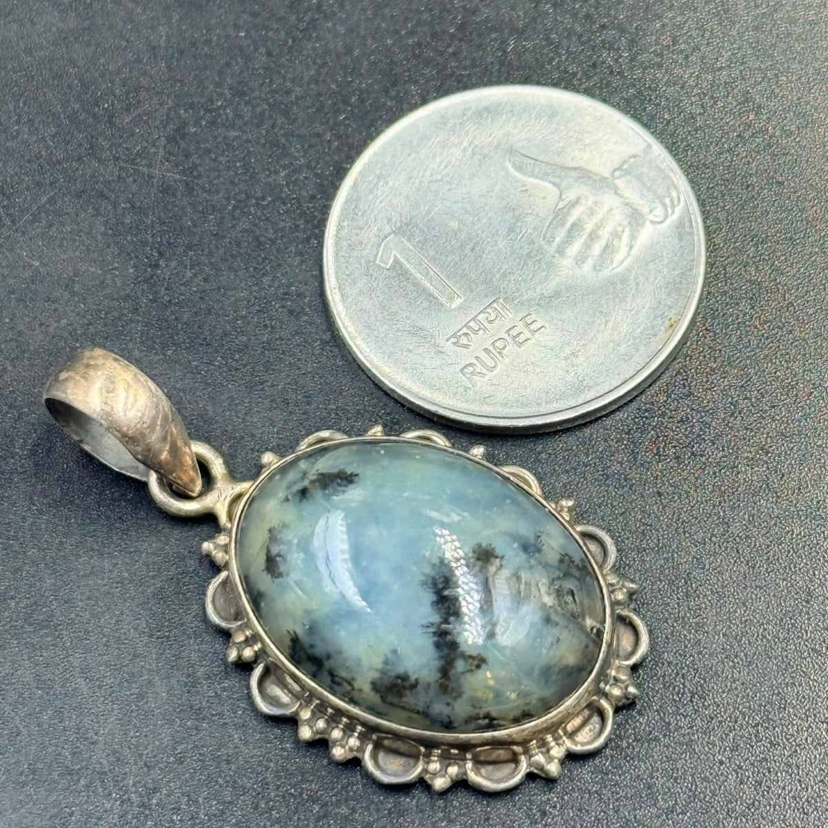 Dendritic opal 925 silver locket pendant with ornate bezel shown next to a quarter