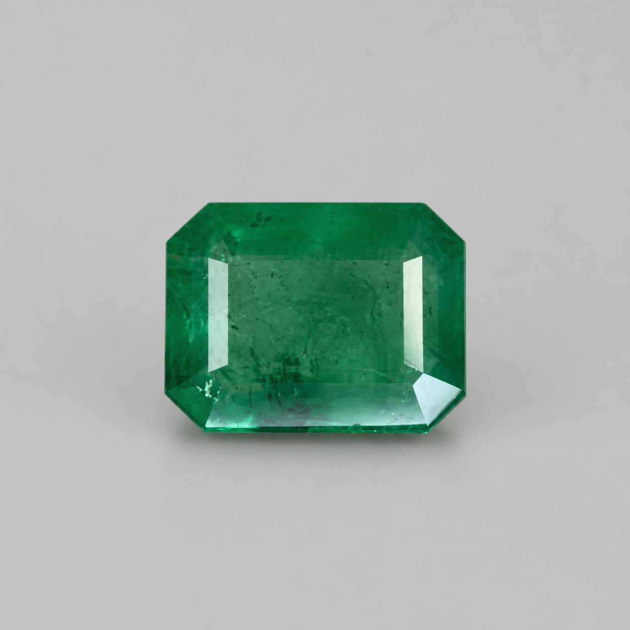 Emerald 5.86-carat green gemstone with emerald-cut step facets on a light background