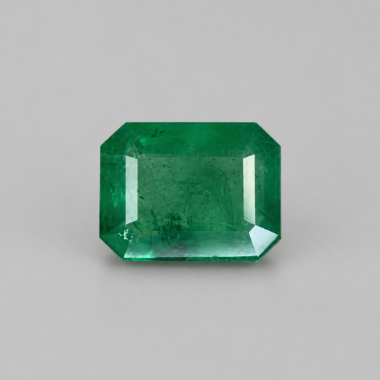 Emerald 5.86-carat green gemstone with emerald-cut step facets on a light background