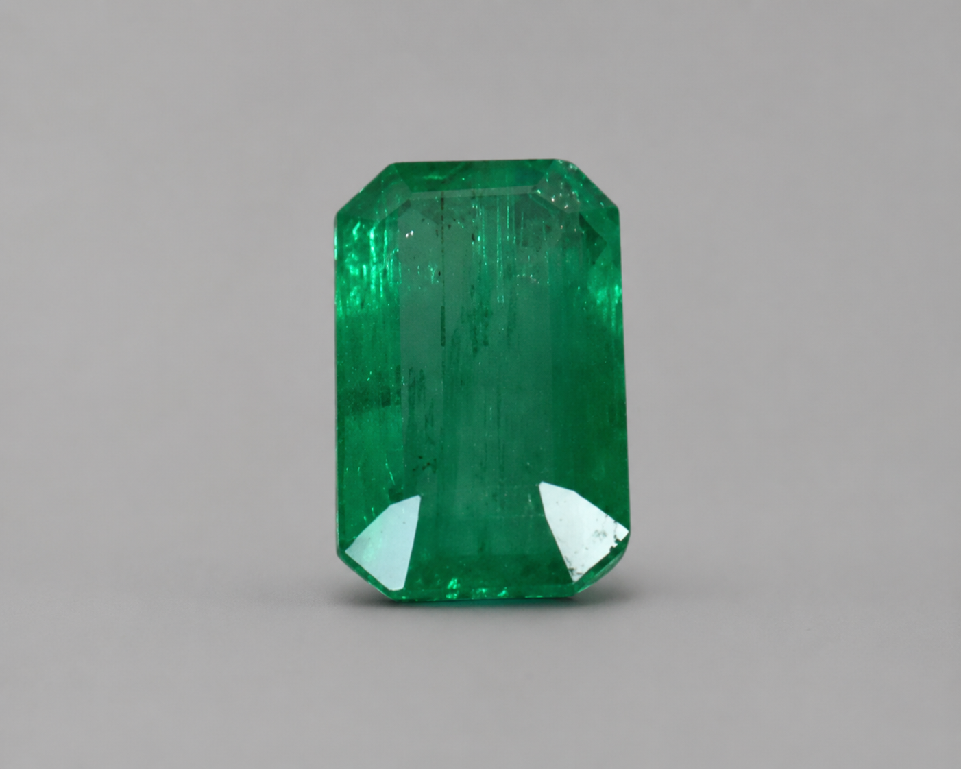 Emerald cut green emerald gemstone with step facets in front view
