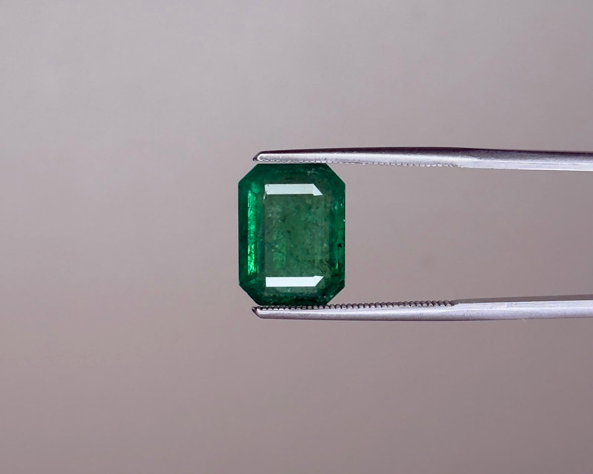 Emerald green emerald gemstone in an emerald-cut with prong set view