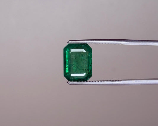 Emerald green emerald gemstone in an emerald-cut with prong set view