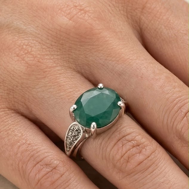 Emerald green panna gemstone ring on hand with 925 silver setting and decorative side