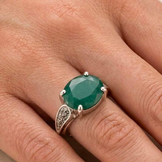 Emerald green panna gemstone ring on hand with 925 silver setting and decorative side