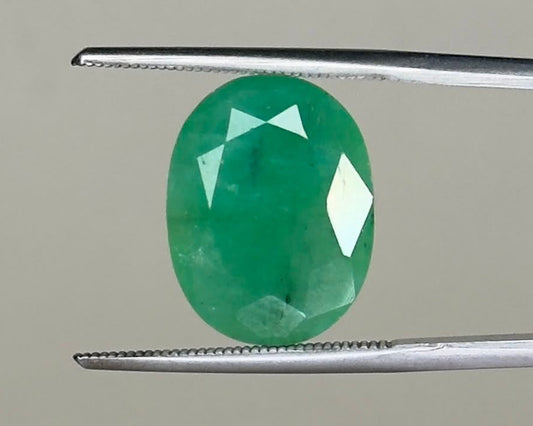 Emerald oval gemstone, 8.62 carats, shown in close-up with prongs