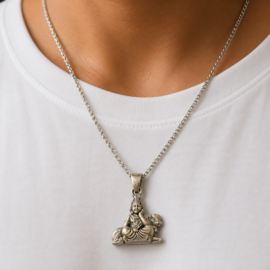 925 silver Gopal Krishna cow and flute pendant worn on a chain against a white shirt
