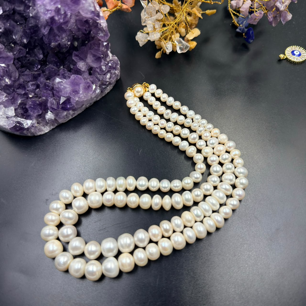 Graduation white pearl 3-layer mala necklace with gold-toned clasp on dark background