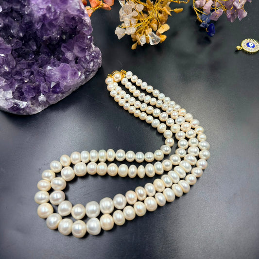 Graduation white pearl 3-layer mala necklace with gold-toned clasp on dark background