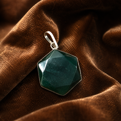 Green Indian jade hexagon locket pendant in silver-tone frame on brown textured cloth