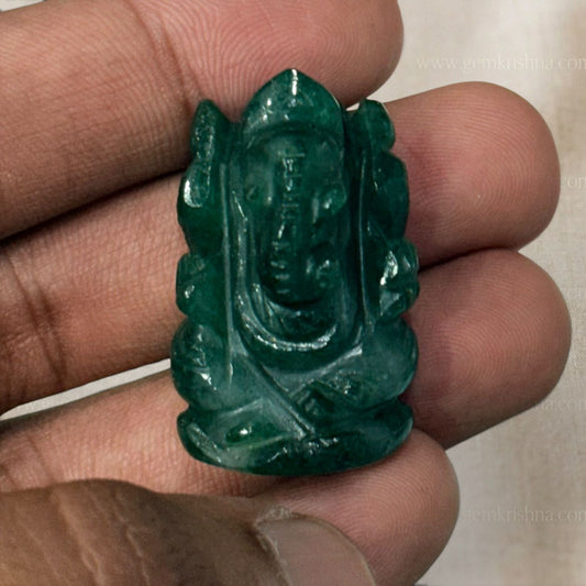 Green jade Ganesh Ji idol figurine with polished finish held in fingers