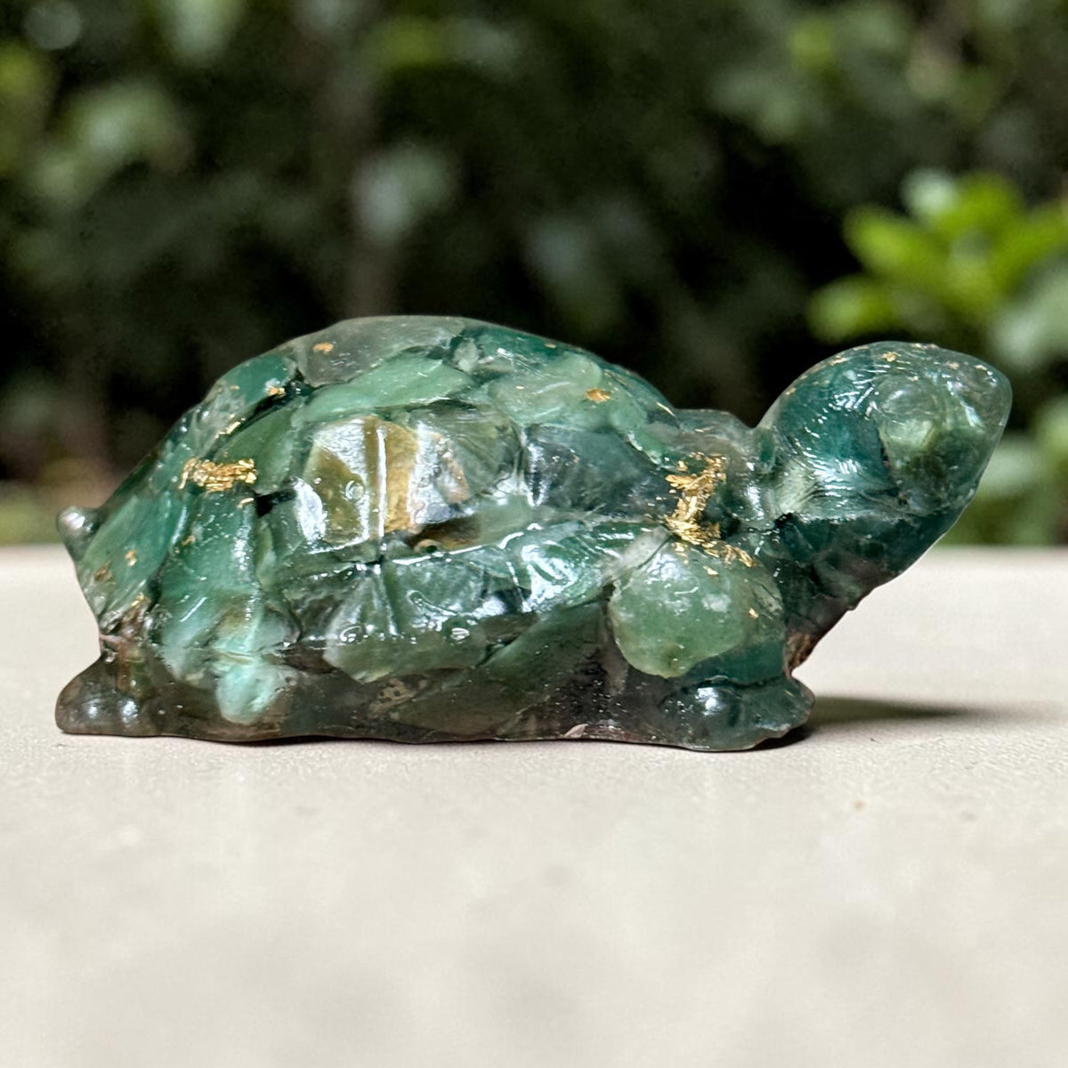 Green jade turtle figurine close-up with glossy surface and gold-tone flecks