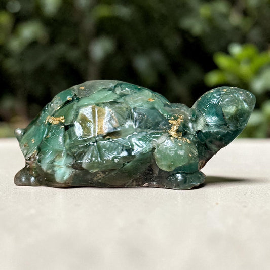 Green jade turtle figurine close-up with glossy surface and gold-tone flecks