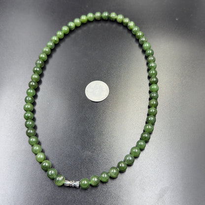 Natural green nephrite jade bead necklace strand shown for size with silver clasp and coin
