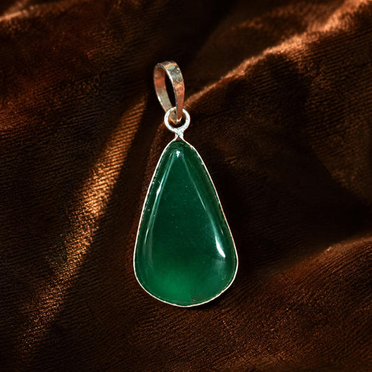 Green onyx pear-shaped locket pendant with silver-tone loop on dark textured background