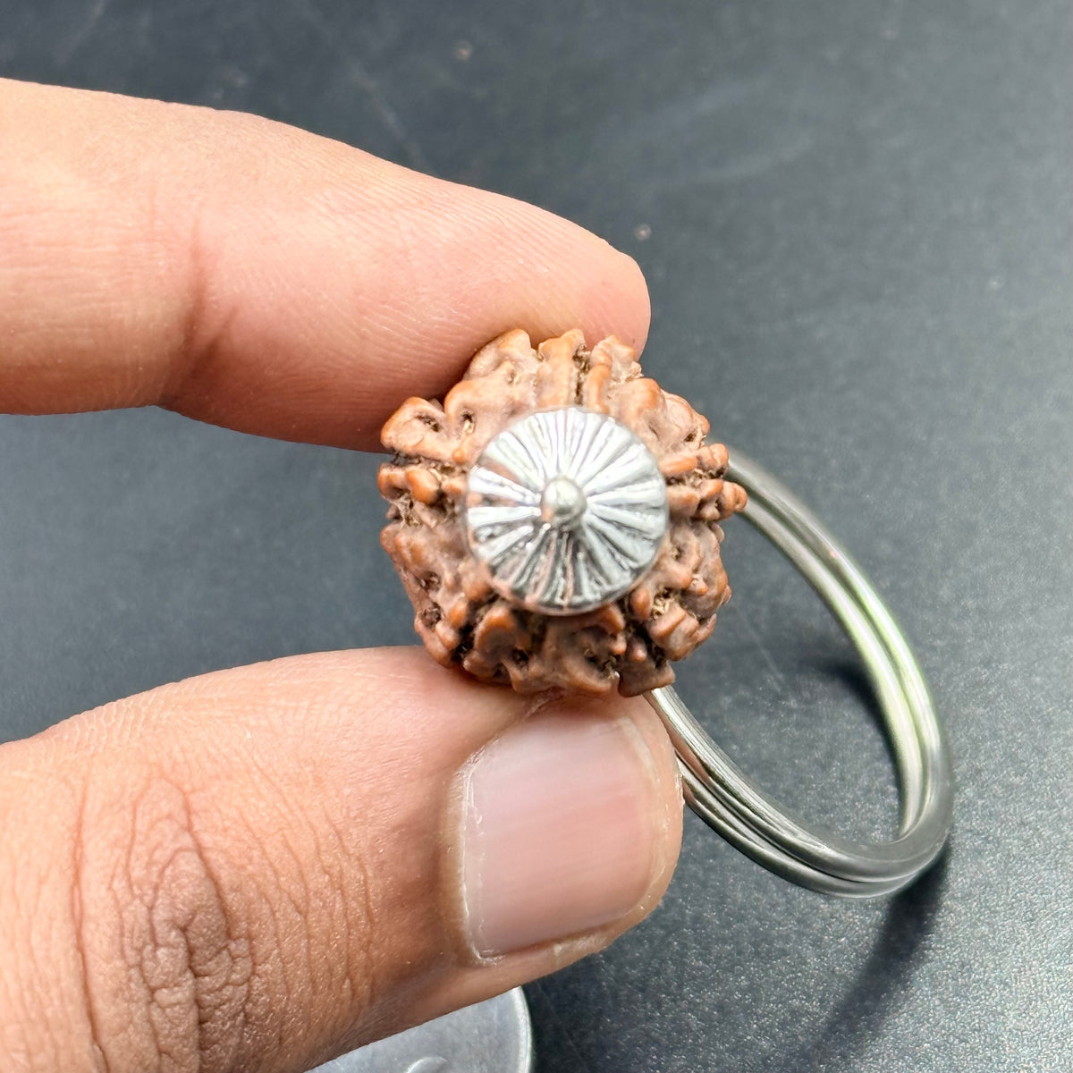 Hand holds rudraksha keychain 4 5 6 mukhi pendant with silver-tone metal ring
