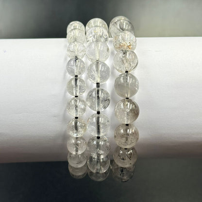 Herkimer Diamond bracelet beads close-up with clear faceted stones and reflections on a dark stand