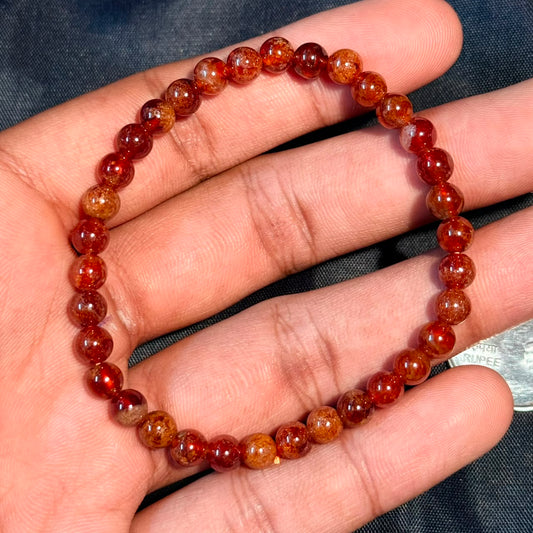 Round red hessonite garnet bead bracelet held in hand, Siloni Gomed and Rahu stone