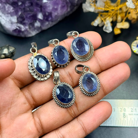 Iolite 925 silver oval locket pendant with textured bezel in hand on dark background