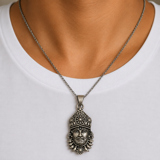 Khatu Shyam Ji face pendant hanging on a silver chain worn on a white shirt