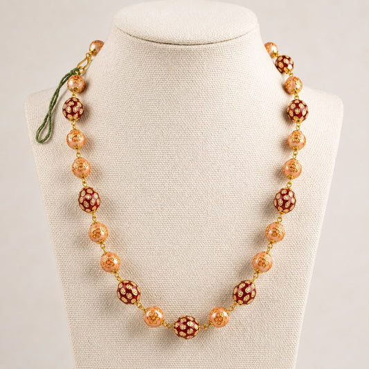 Kundan bead mala necklace with red and peach floral bead design on cream fabric display