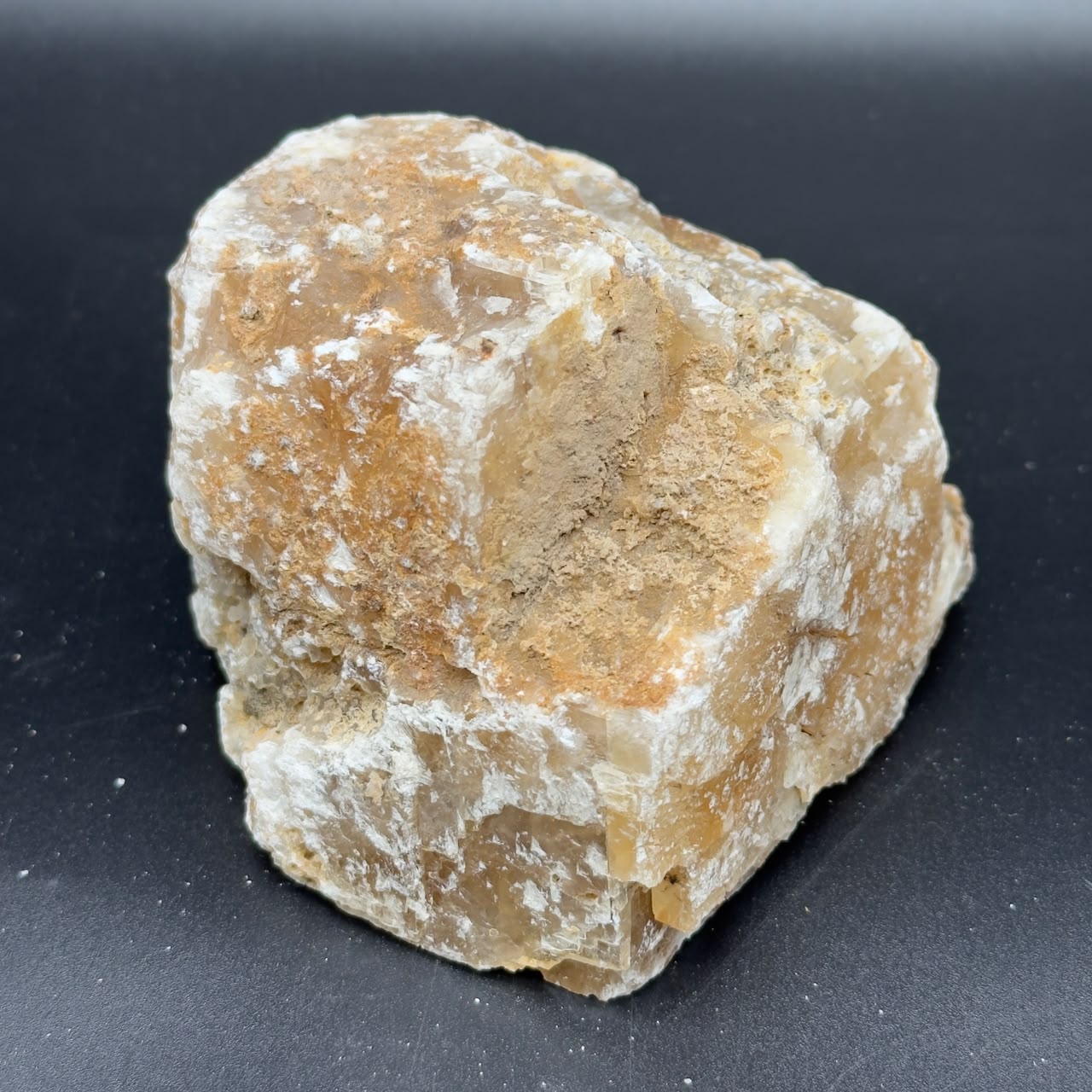 Large rough golden calcite crystal face showing white and amber bands