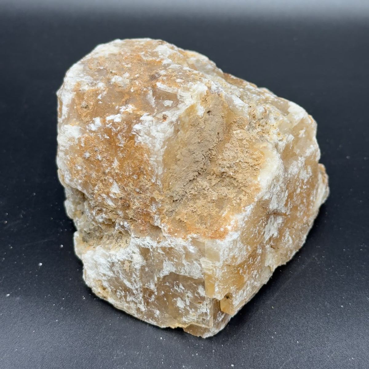 Large rough golden calcite crystal face showing white and amber bands
