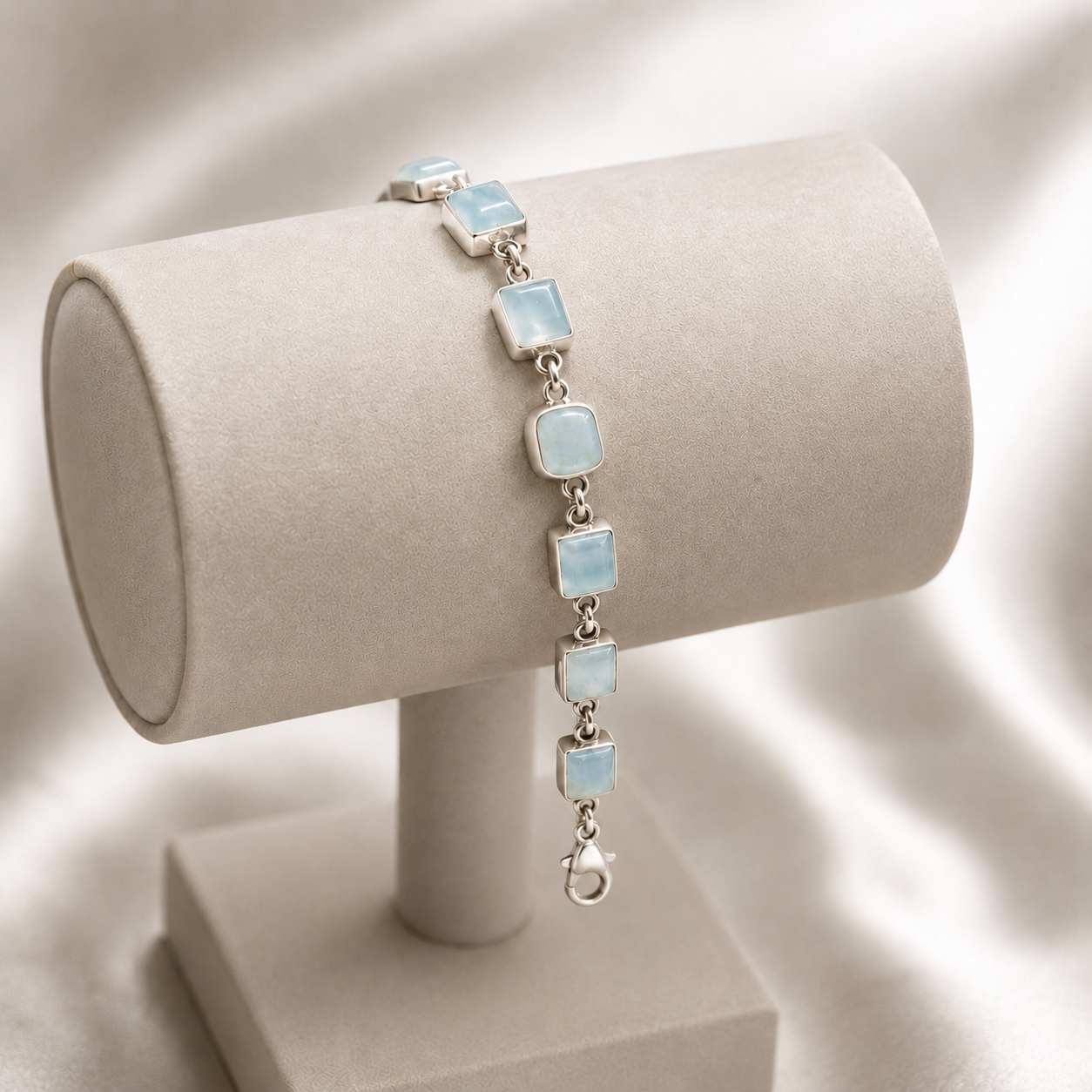 Square larimar cabochon bracelet on beige jewelry display with 925 silver chain links