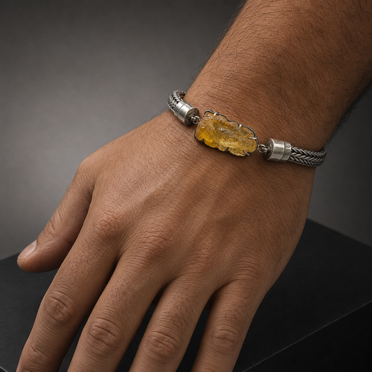 Citrine Ganesha bracelet shown on a man’s wrist with silver chain and yellow gemstone pendant